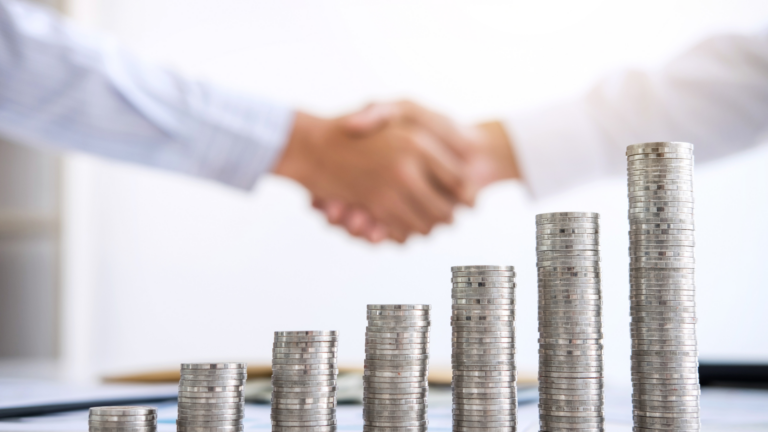 two indivudals in buttoned down shirts are shaking hands, you can only see their arms and wrists. in the foreground is a stack of goings, each stack is larger than the previous, increasing from left to right.