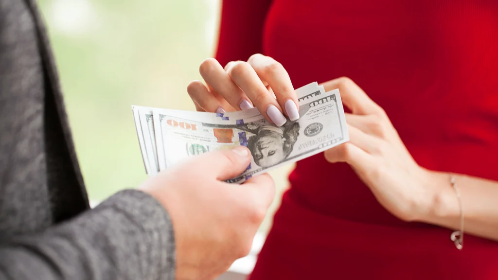 Business woman sharing money with another woman
