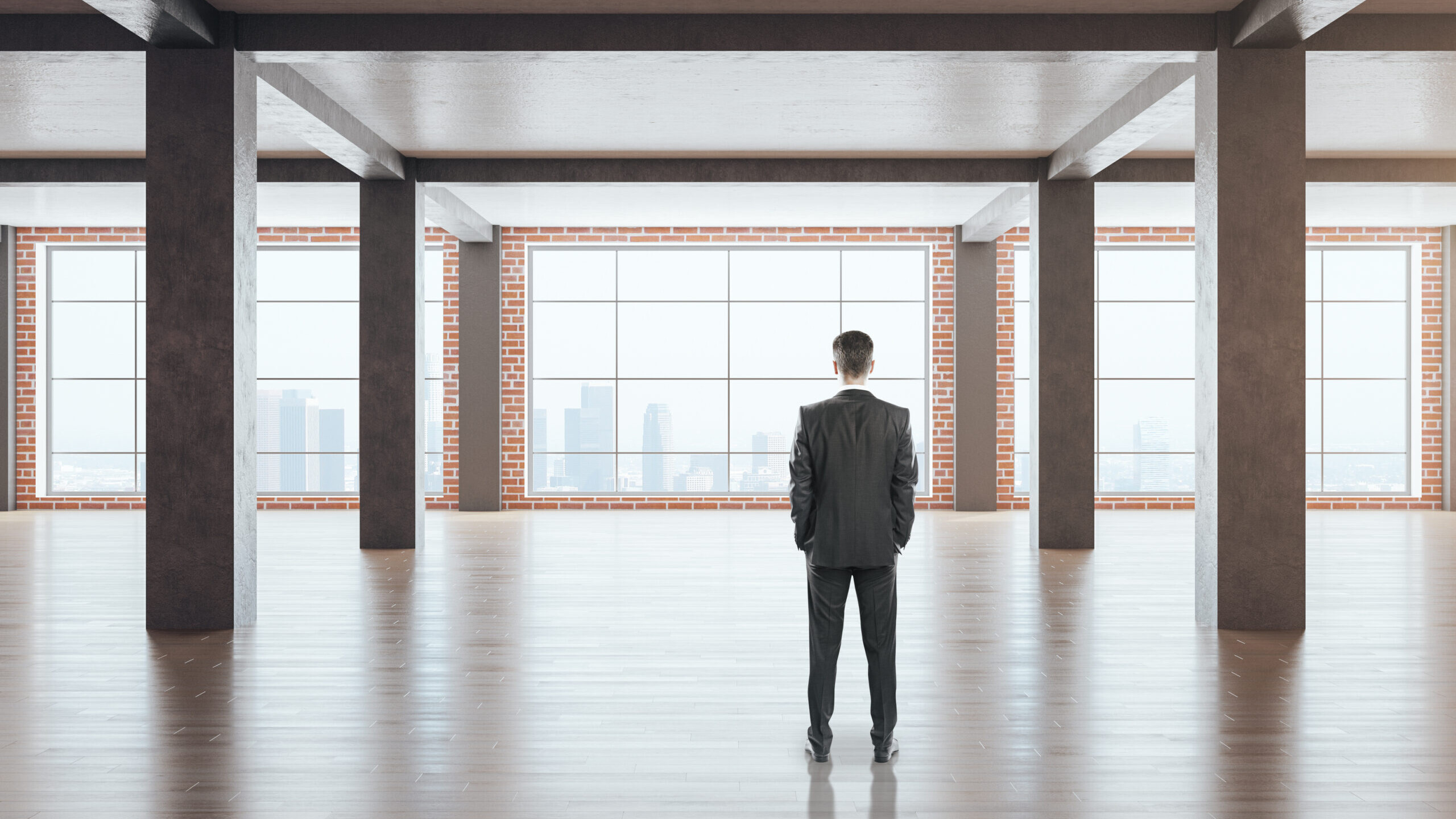 Self-employed real estate investor standing in an empty commercial building, evaluating a property investment opportunity