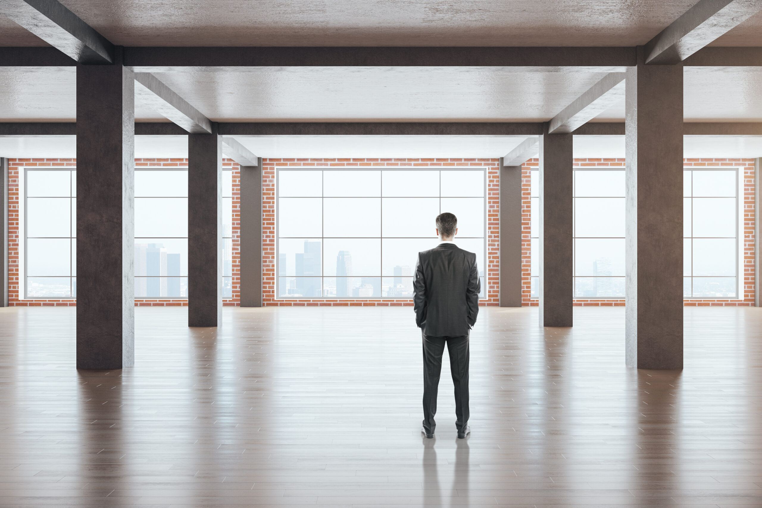 Self-employed real estate investor standing in an empty commercial building, evaluating a property investment opportunity