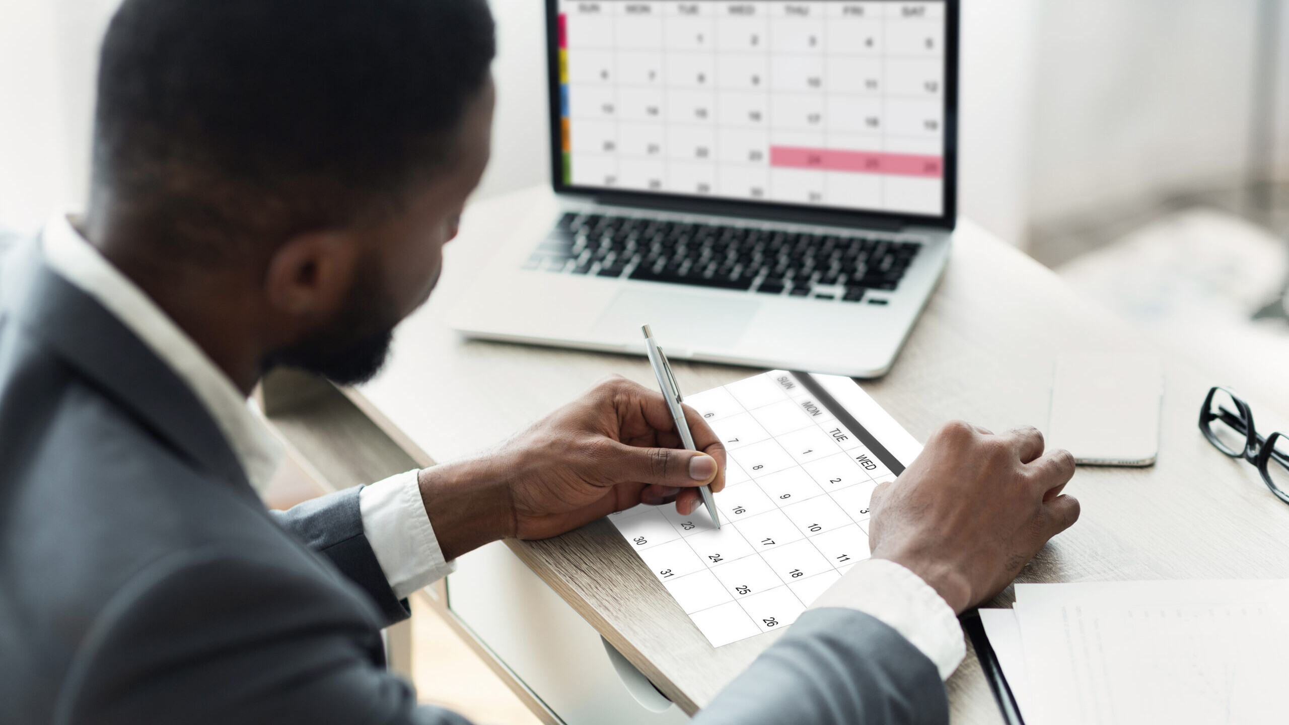 Business owner marking deadlines on a calendar while working through a Solo 401(k) year-end checklist