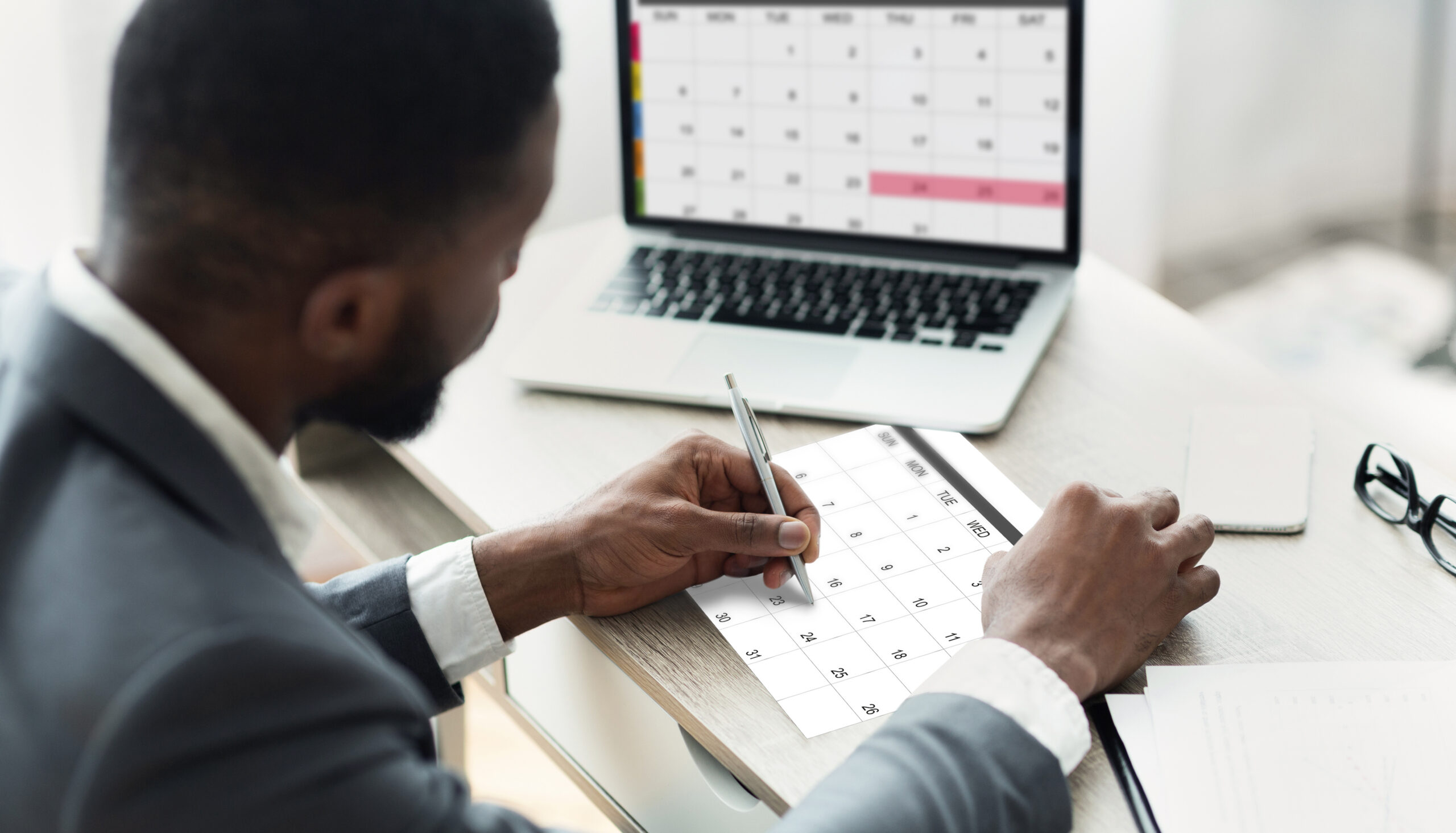 Business owner marking deadlines on a calendar while working through a Solo 401(k) year-end checklist