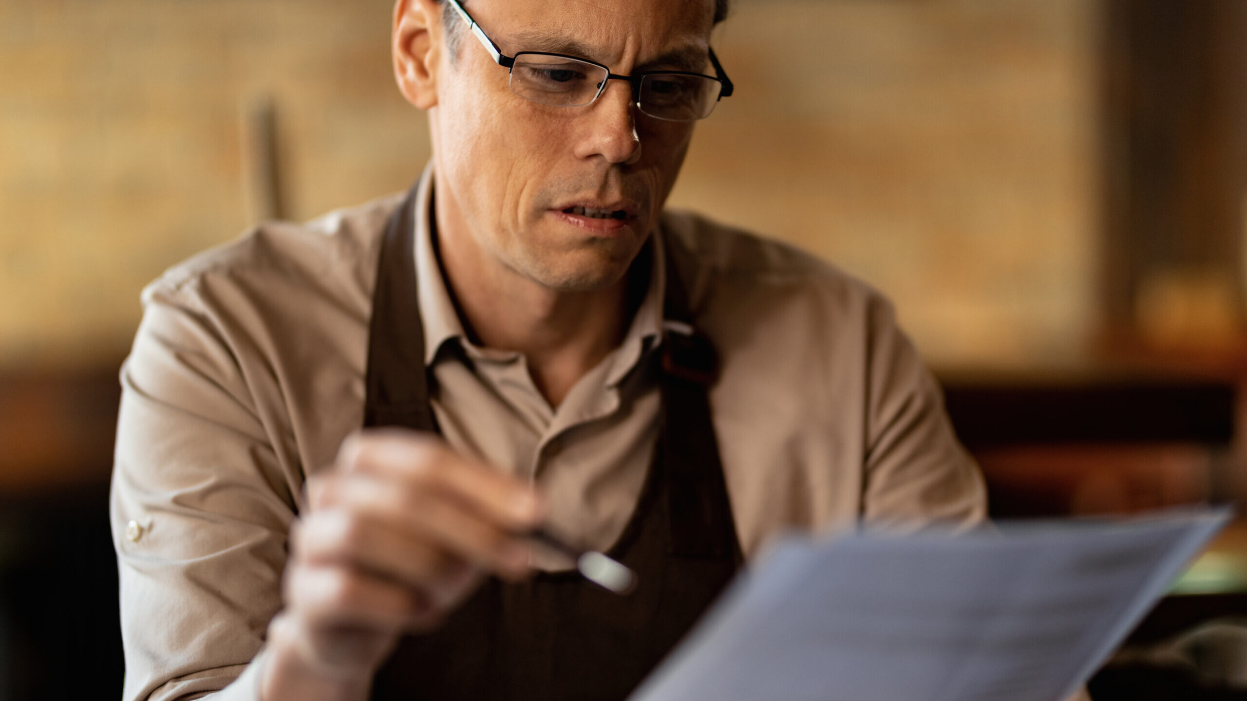 Restaurant owner reviewing a letter after being declined for a small business loan