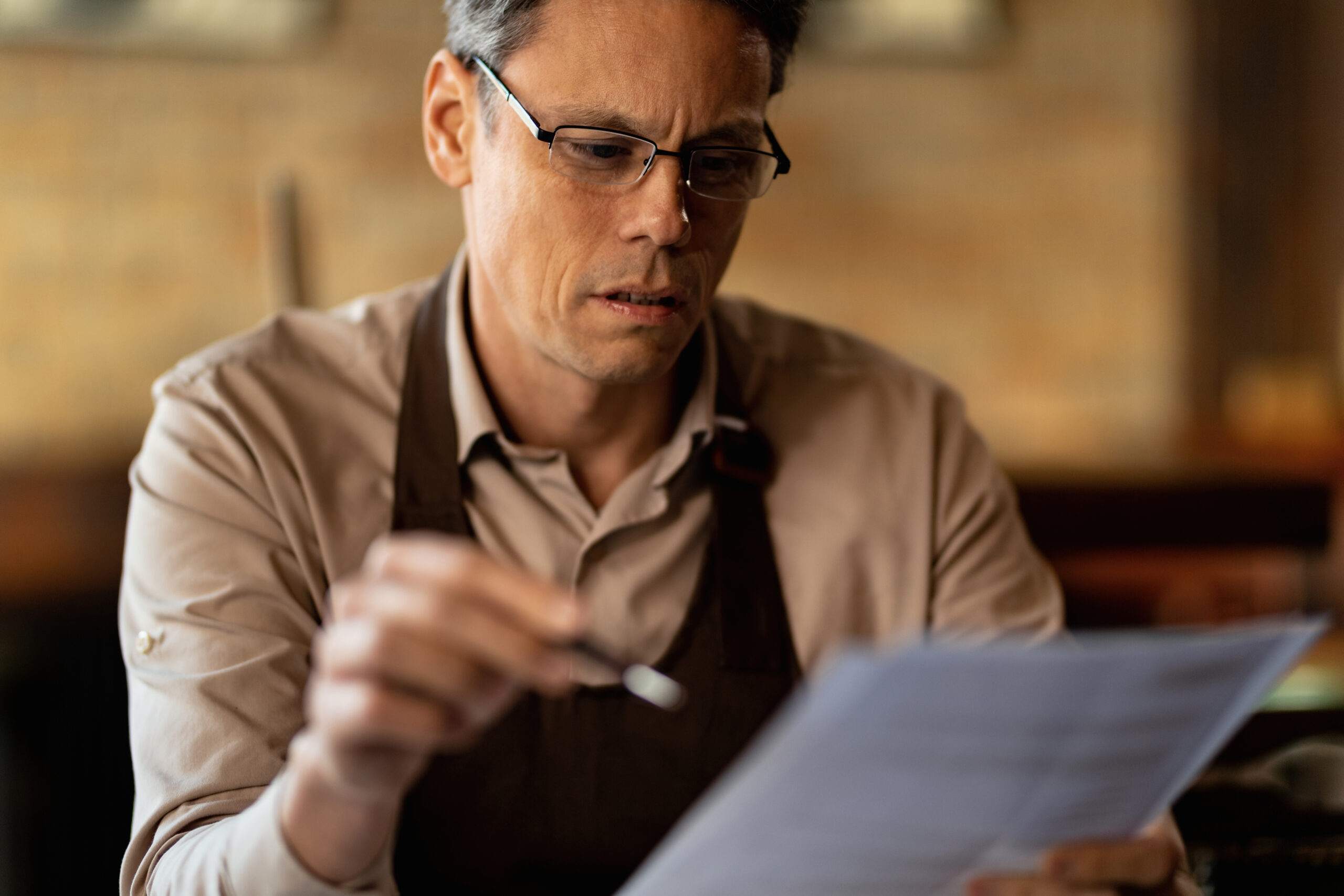 Restaurant owner reviewing a letter after being declined for a small business loan