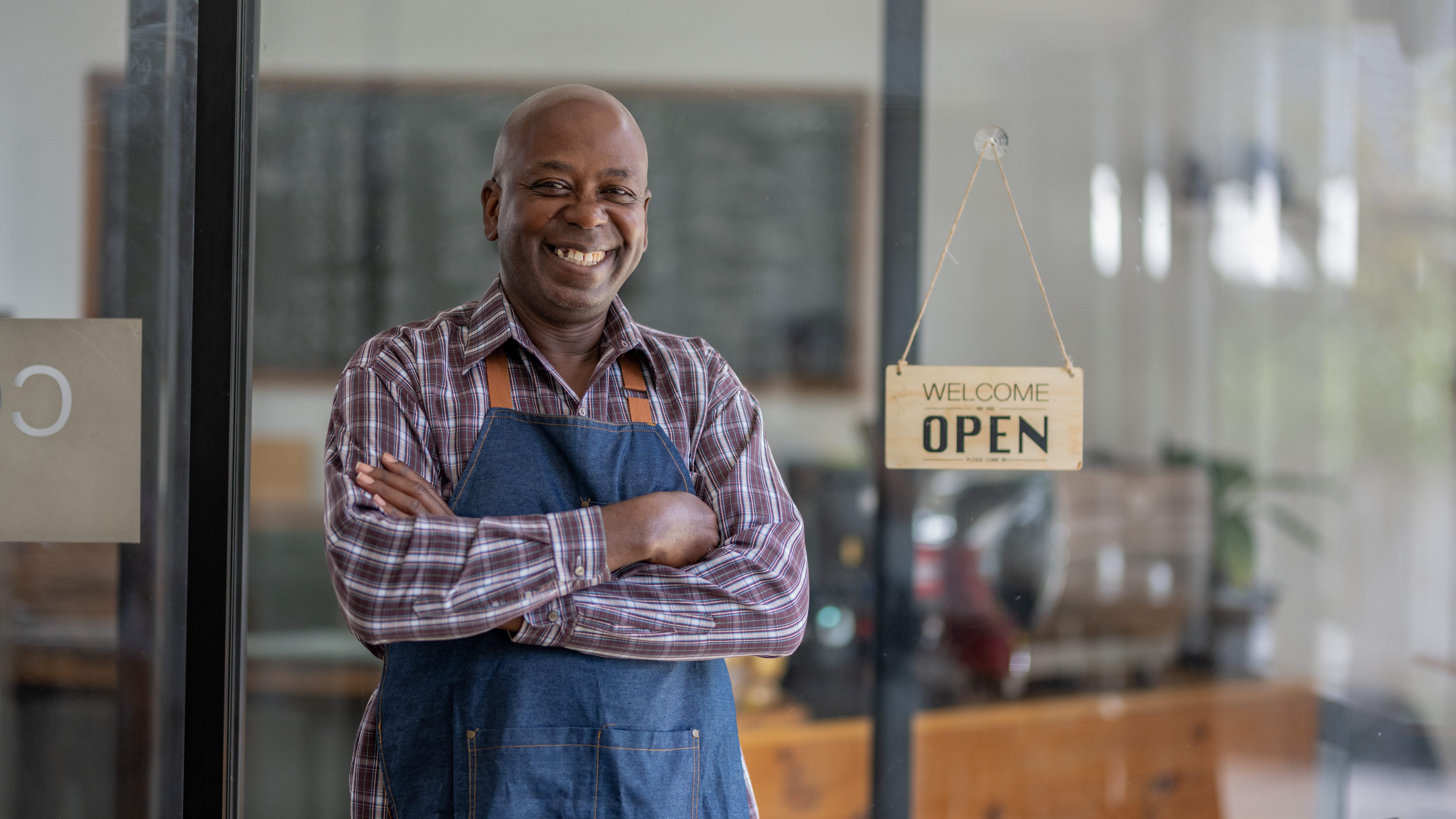 Small business owner standing in his newly opened shop, illustrating the best ways to fund a small business startup