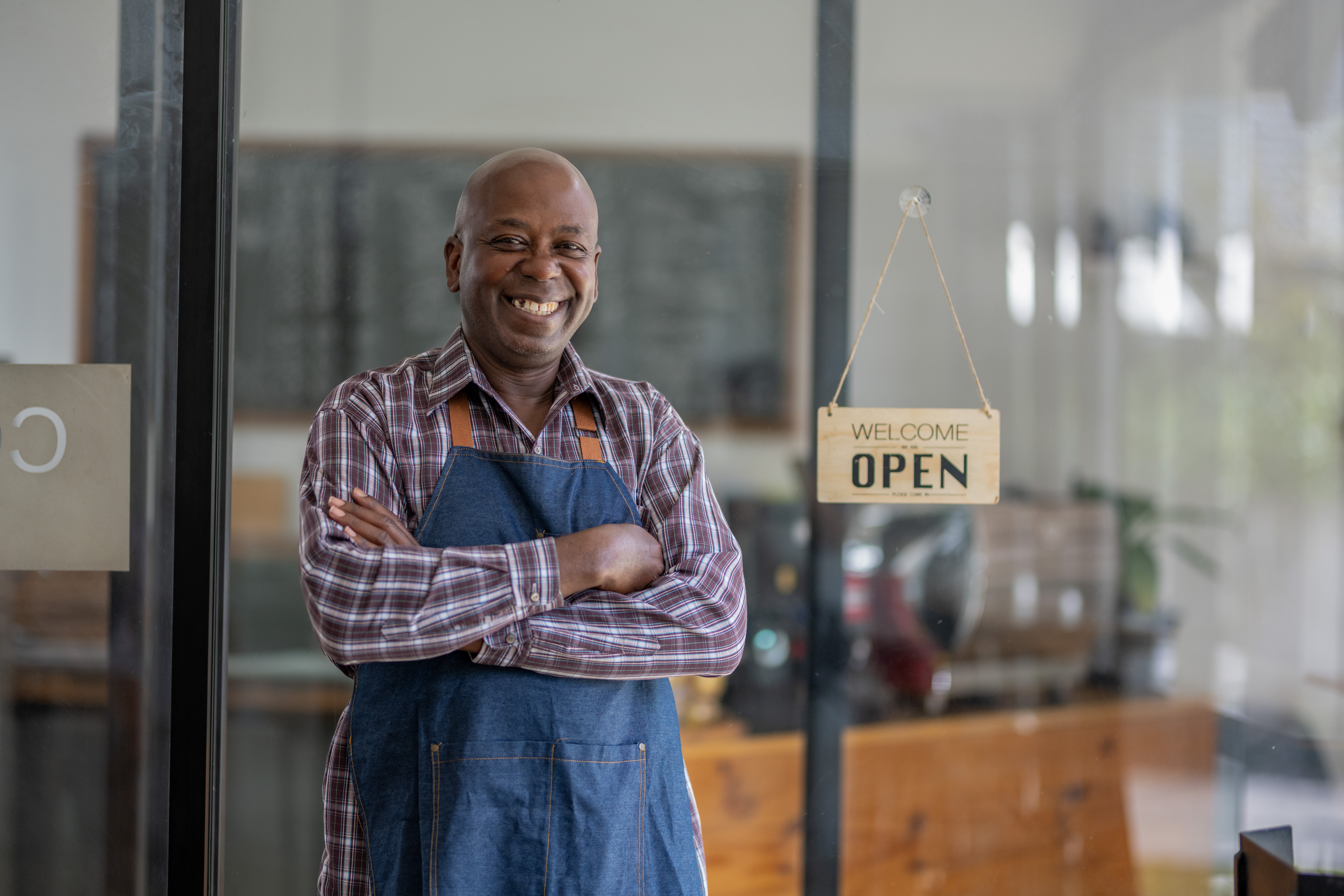 Small business owner standing in his newly opened shop, illustrating the best ways to fund a small business startup
