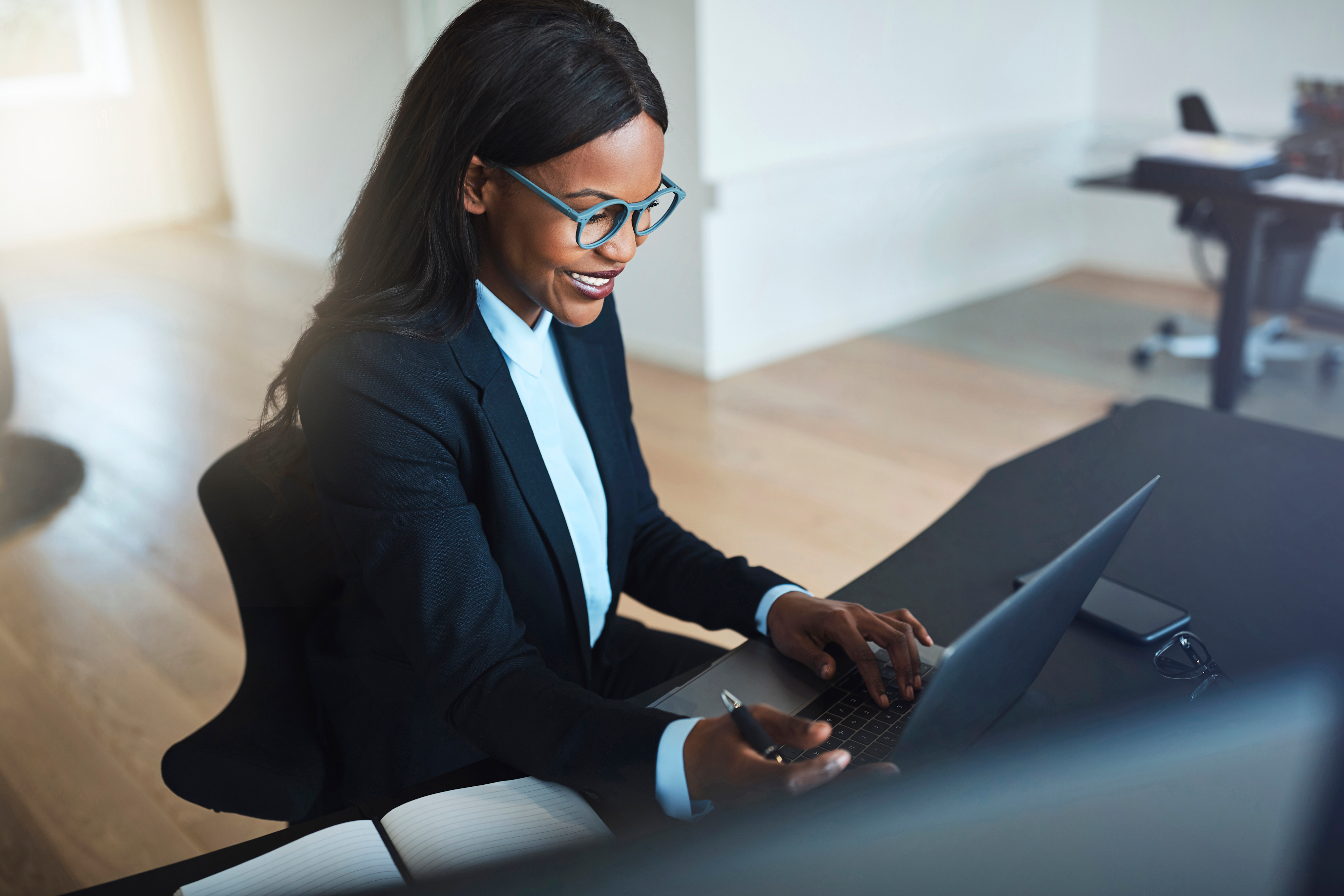Professional IRA financial worker smiling while working on a laptop