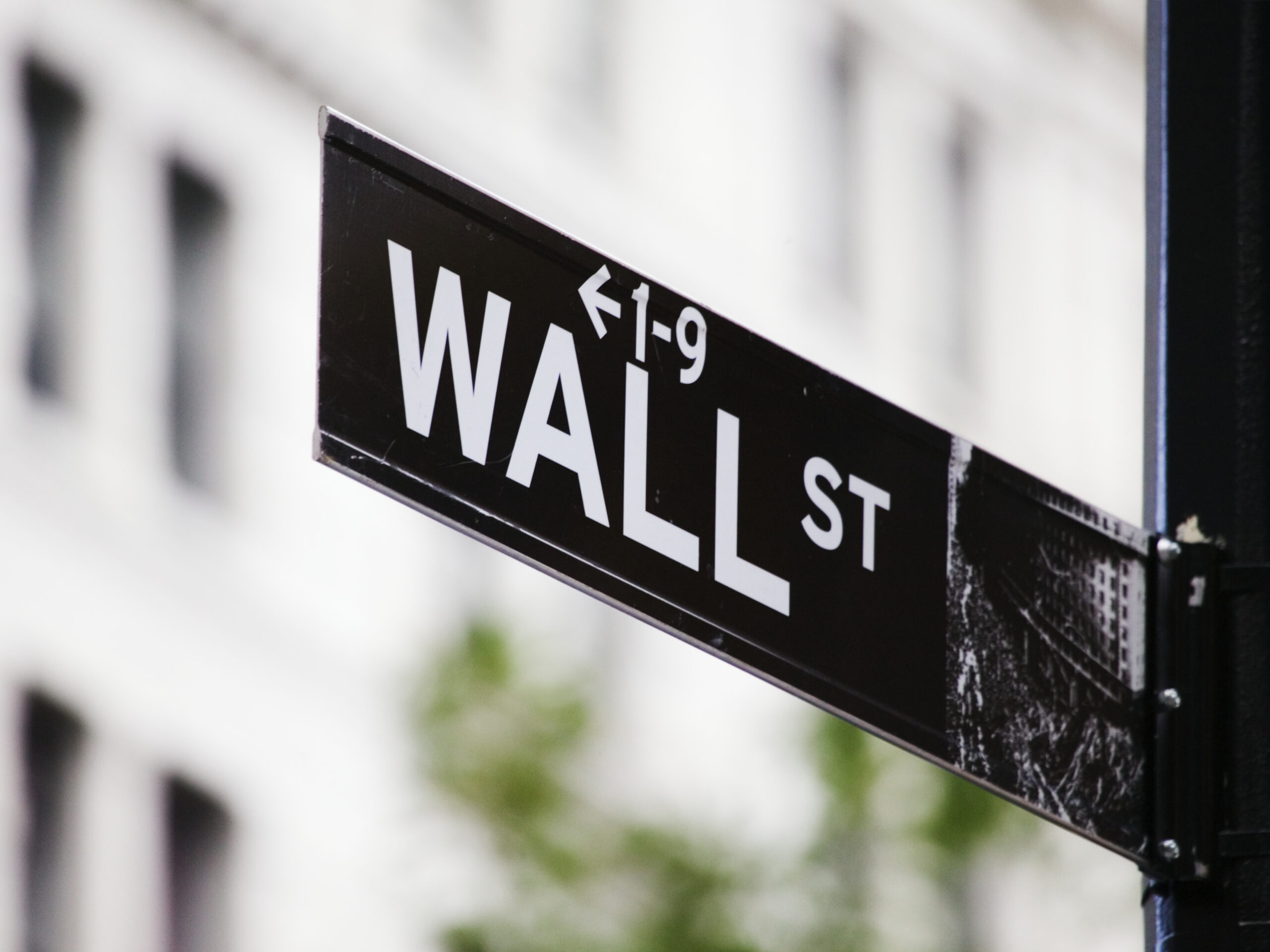 Wall Street sign against a Financial District building, representing regulatory capture in retirement investing